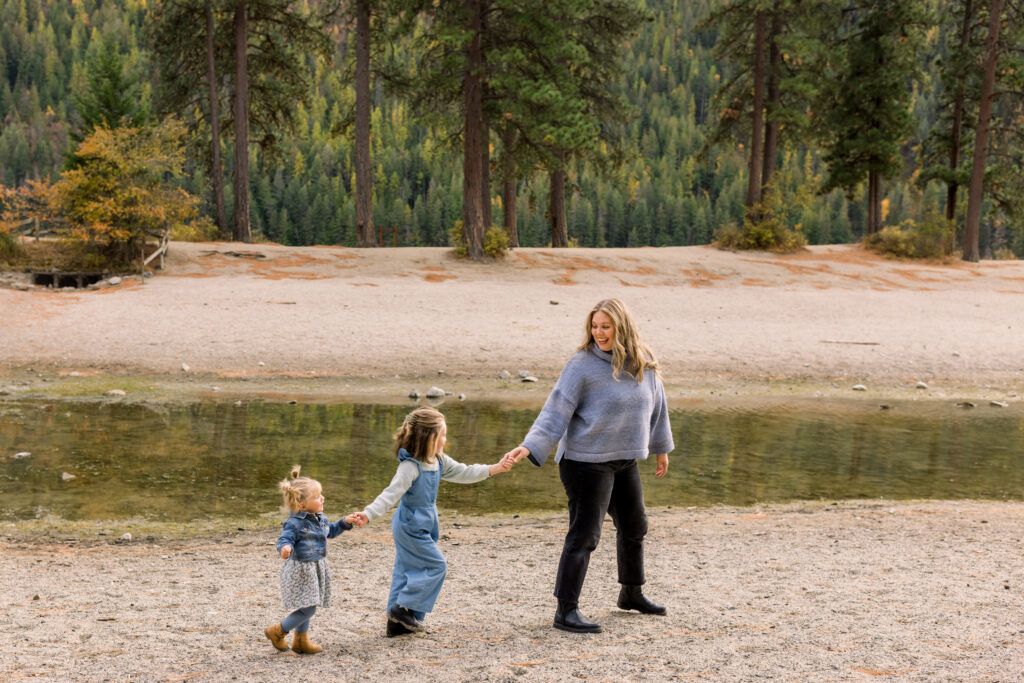 Parents walking hand in hand with their young children during an outdoor family photo session