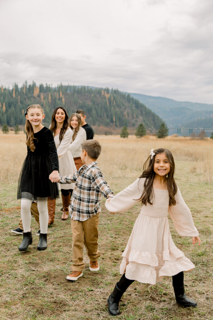 Young child exploring outdoors while being photographed with their family