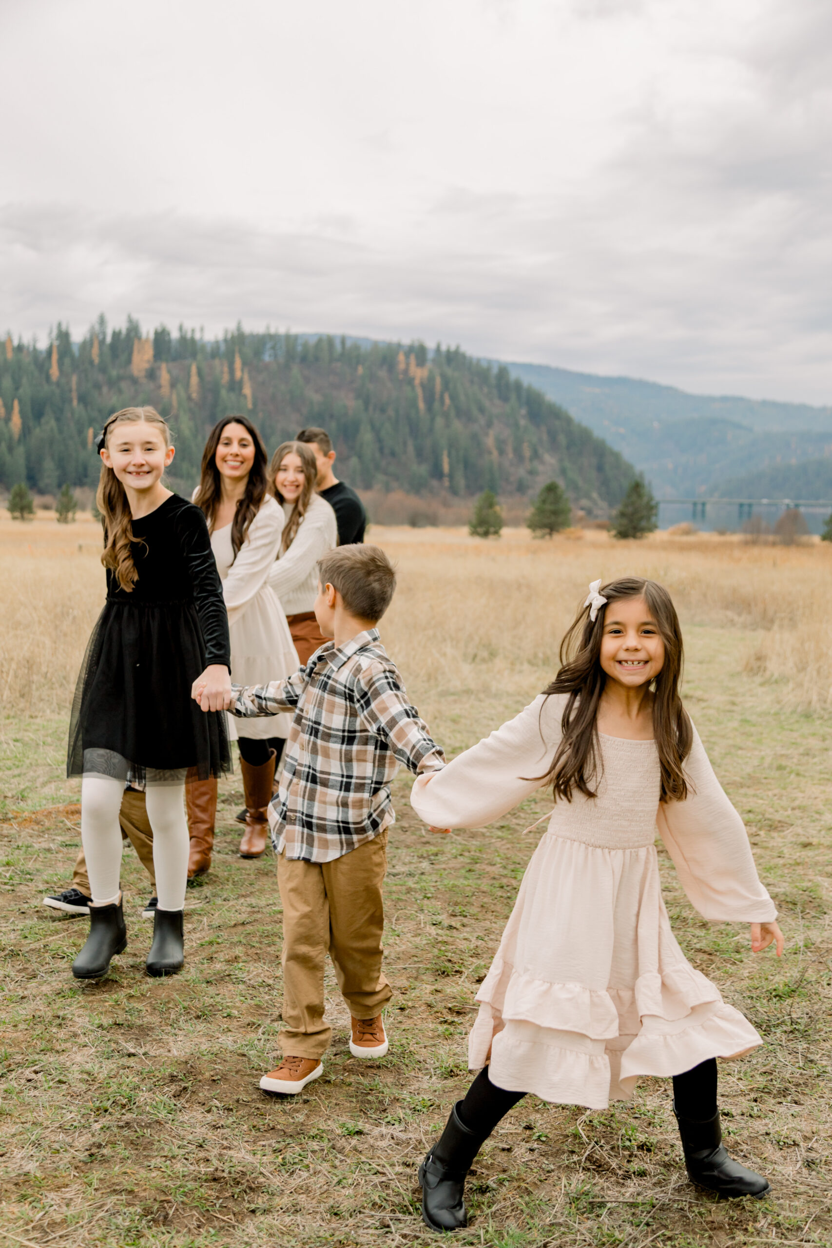 Young child exploring outdoors while being photographed with their family